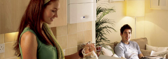 Couple shown in kitchen with boiler